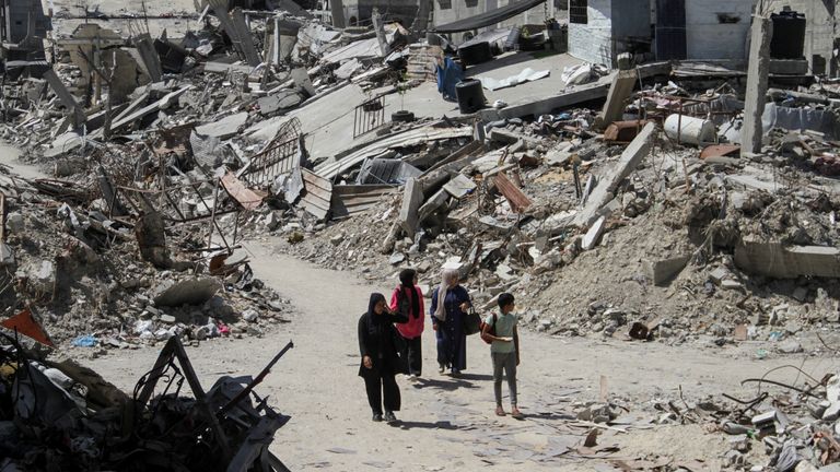 Palestinians walk among the rubble of damaged buildings, which were destroyed during Israel's military offensive, amid the ongoing conflict between Israel and Hamas, in Beit Lahia in the northern Gaza Strip, June 12, 2024. REUTERS/Mahmoud Issa
