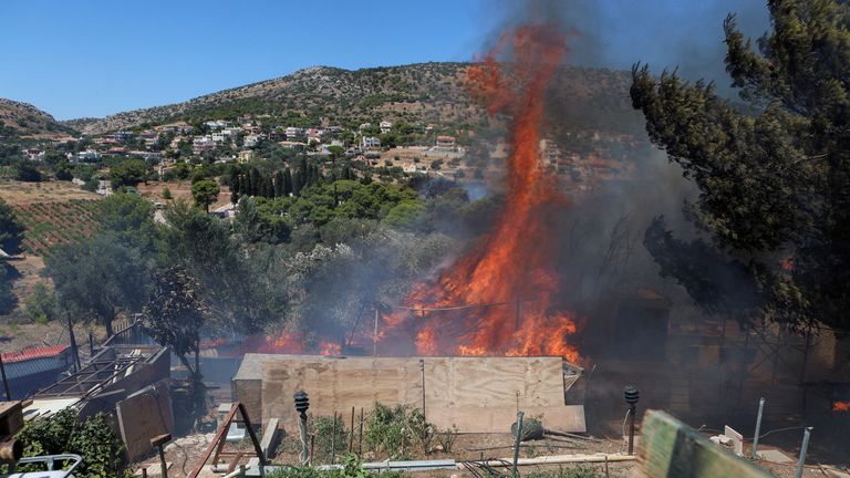 Fires engulf a house in Keratea, near Athens on Sunday. Pic: Reuters