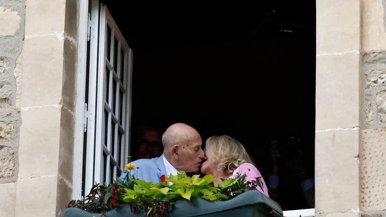 US WWII veteran Harold Terens, 100, left, and Jeanne Swerlin, 96, kiss from a window after celebrating their wedding at the town hall of Carentan-les-Marais, in Normandy, northwestern France, on Saturday, June 8, 2024. Together, the collective age of the bride and groom was nearly 200. But Terens and his sweetheart Jeanne Swerlin proved that love is eternal as they tied the knot Saturday inland of the D-Day beaches in Normandy, France. (AP Photo/Jeremias Gonzalez)