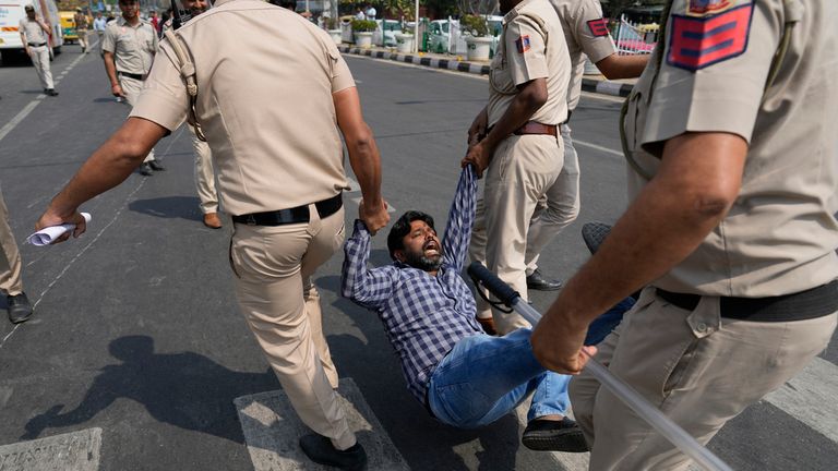 A supporter of Aam Admi Party, or Common Man's Party, is detained by the police officials during a protest against the arrest of their party leader Arvind Kejriwal, in New Delhi, India, Friday, March 22, 2024. Supporters of an anti-corruption crusader and one of India's most consequential politicians of the last decade in India held protests Friday against his arrest, which opposition parties say is part of a crackdown by Prime Minister Narendra Modi's government before national elections. (AP Photo/Manish Swarup)