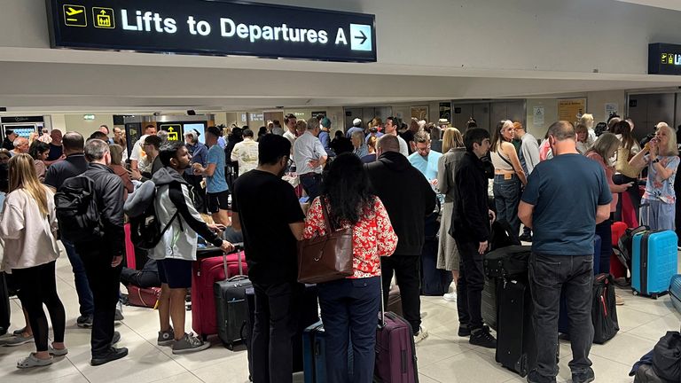Passengers queue outside Terminal 1. Pic: Reuters