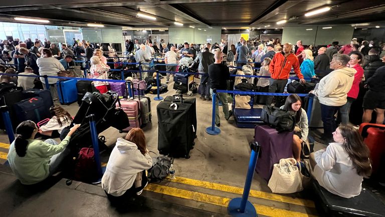 Passengers queue outside Terminal 1. Pic: Reuters