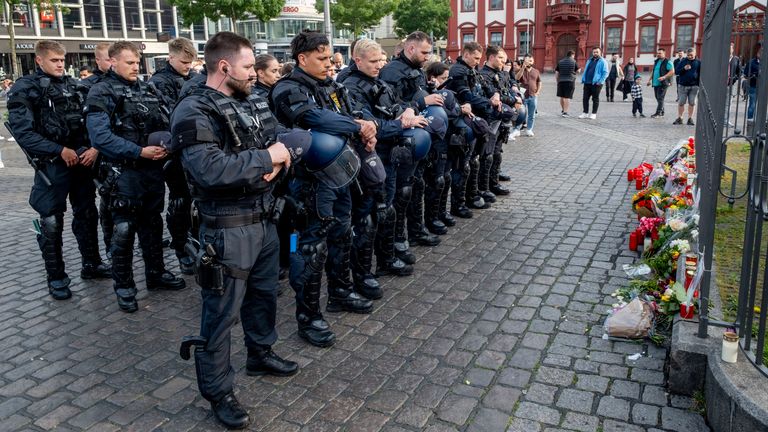 German police officers commemorate a colleague in Mannheim Germany, after learning that a police officer, who was stabbed two days ago there has died on Sunday, June 2, 2024. (AP Photo/Michael Probst)