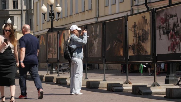 A woman takes photos of art about Russia's war in Ukraine in Moscow