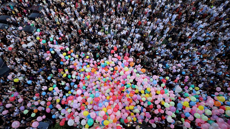People attempt to catch balloons released after an Eid al-Adha prayer at a public park, outside El-Seddik Mosque in Cairo, Egypt. Pic: Reuters
