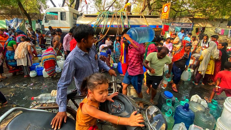 Indians gather around a water truck at the Vivekanand camp in in New Delhi during extreme heat in June 2024