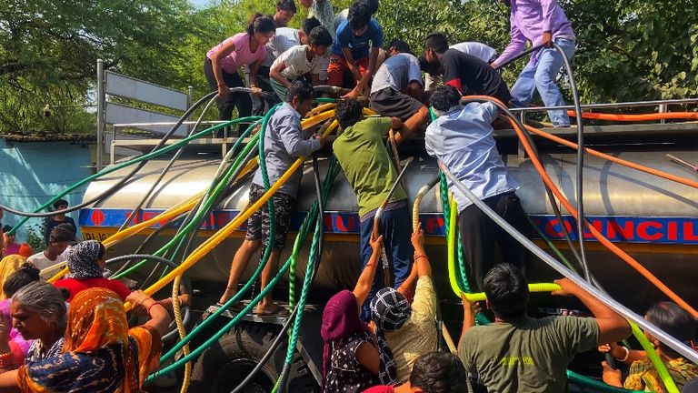 Indians gather around a water truck at the Vivekanand camp in New Delhi during extreme heat in June 2024