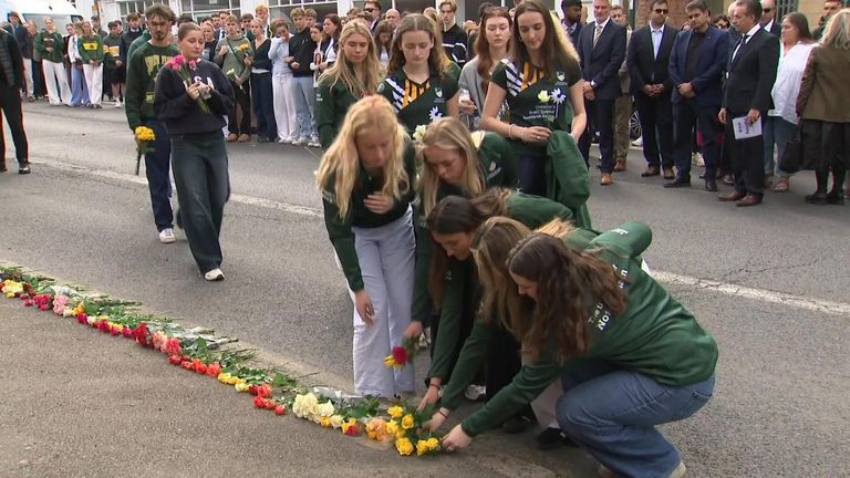 Families and friends of the Nottingham attack victims have laid roses where the two students were murdered a year ago.