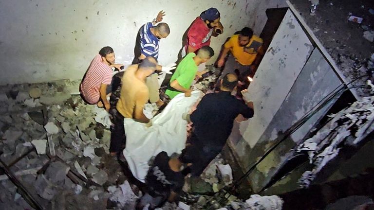 The body of a Palestinian killed in the Israeli strike on a UNRWA school sheltering displaced people in Nuseirat refugee camp in central Gaza is removed. Pic: Reuters