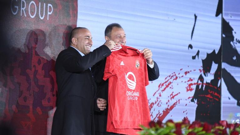Al Organi holds up an al Ahly football jersey 