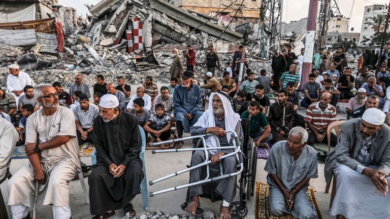 Palestinians perform Eid al-Adha prayer next to destroyed homes by Israeli warplanes in the city of Khan Younis in the southern Gaza Strip.  