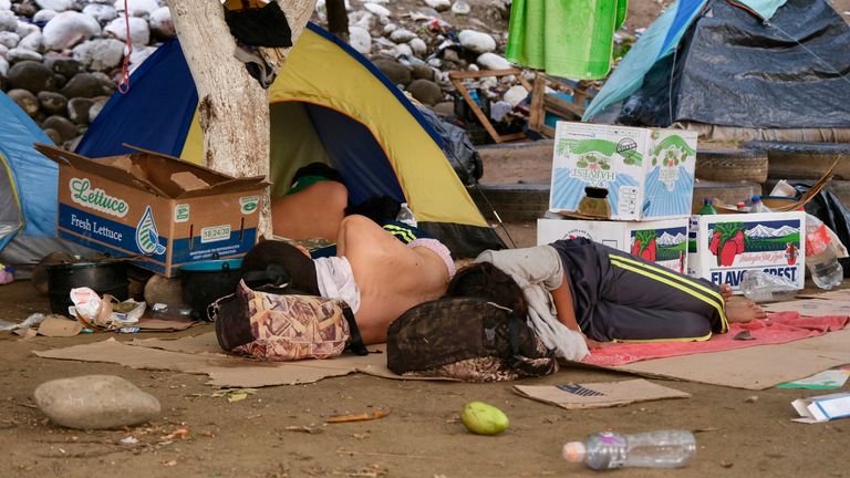 A migrant sleeps near the river 