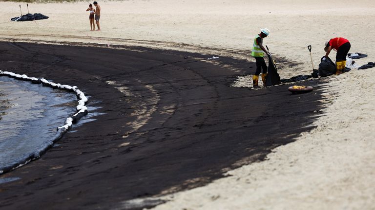 Workers clean up the beach following an oil slick, at Tanjong Beach in Sentosa, Singapore .
Pic: Reuters
