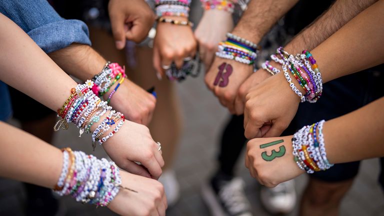Taylor Swift fans pose with their bracelets outside Wembley Stadium before the first London concert of the Eras Tour on Friday, June 21, 2024 in London. (Photo by Scott A Garfitt/Invision/AP)