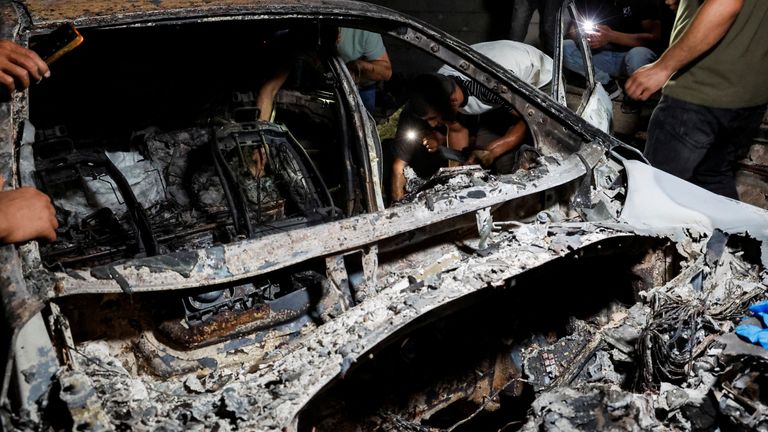 Palestinians inspect a damaged car following an Israeli military operation, in Qabatiya, near Jenin, in the Israeli-occupied West Bank, June 13, 2024. REUTERS/Raneen Sawafta
