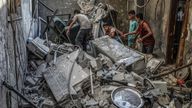 Palestinians inspect a damaged house following an Israeli attack in Gaza on 9 July. Pic: Abed Rahim Khatib/picture-alliance/dpa/AP Images