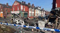 A burnt out car in the Leeds suburb of Harehills, after vehicles were set on fire and a police car was overturned. Pic: PA