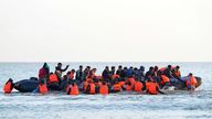 A group of people thought to be migrants wade through the sea to clamber aboard a small boat off the beach in Gravelines, France. Picture date: Monday July 29, 2024.
