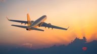 A plane flies towards a cloudy sunset. Pic: iStock