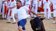 A reveller sprints as a bull runs at the San Fermin festival in Pamplona. Pic: Reuters