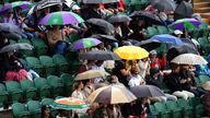 Spectators take shelter from the rain on day five of the 2024 Wimbledon Championships at the All England Lawn Tennis and Croquet Club, London. Picture date: Friday July 5, 2024.