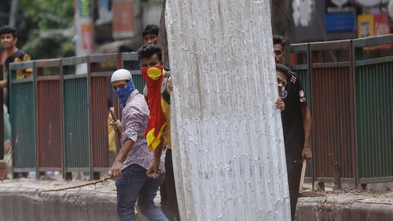 Demonstrators shield themselves with a metal sheet. Pic: Reuters