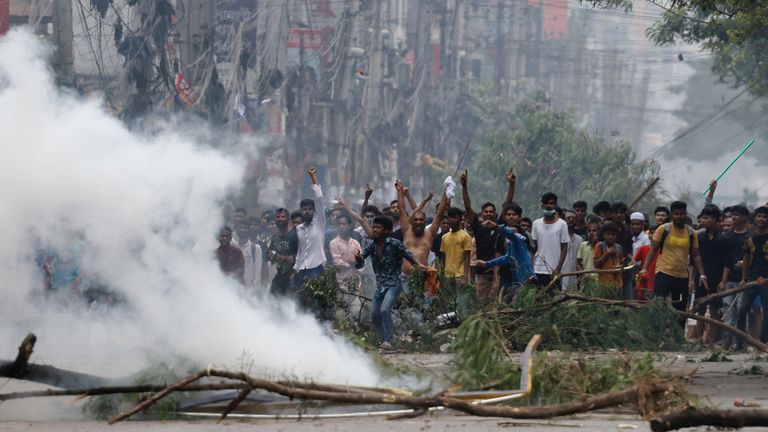 Smoke billows near demonstrators in Dhaka. Pic: Reuters