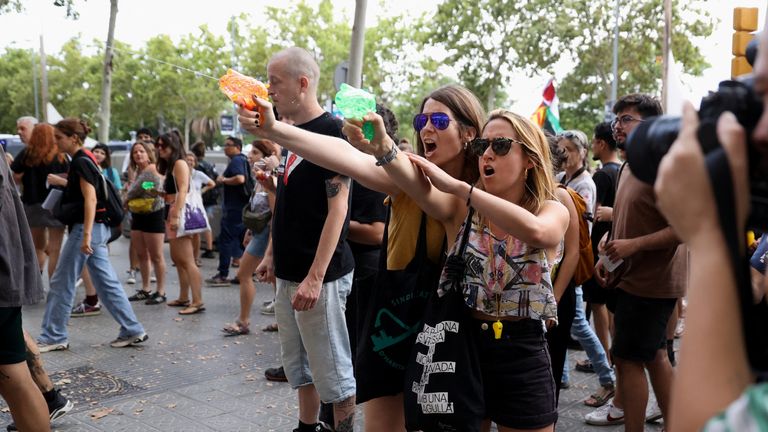 Protesters shoot water from water guns at tourists during a protest against mass tourism in Barcelona, Spain, July 6, 2024. The Catalan capital received more than 12 million tourists in 2023 and expects more in 2024. REUTERS/Bruna Casas