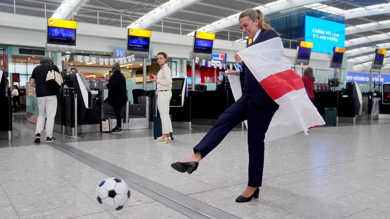 A British Airways worker kicks a football at Heathrow Airport ahead of the game. Pic: PA