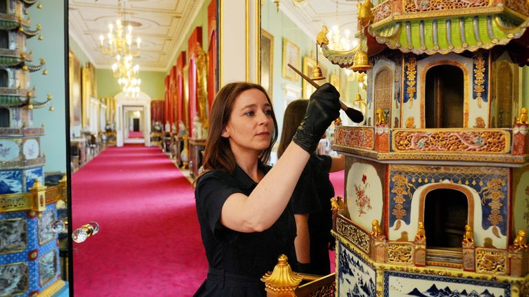 Final preparations are made in the Principal Corridor, where a member of Royal Collection Trust staff tends to a Chinese pagoda, in the East Wing of Buckingham Palace, London, which is being opened to visitors for the first time this summer, when special guided tours of the Principal Floor will be available to visitors in July and August. Picture date: Monday July 8, 2024.