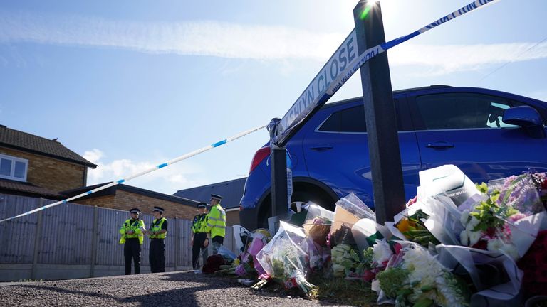 Police officers and flowers at the scene in Ashlyn Close, Bushey.
Pic: PA