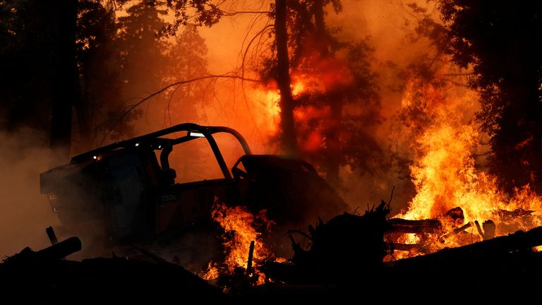 A bulldozer attempts to put out flames in Forest Ranch, California. Pic: Reuters