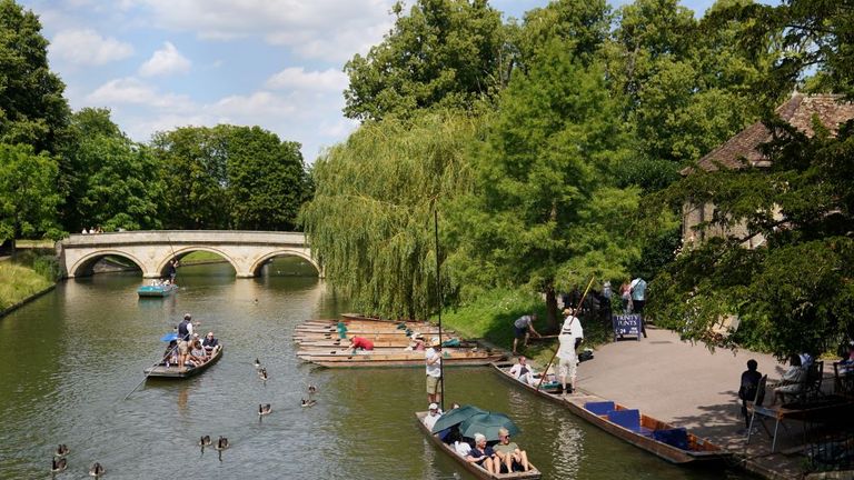 People shelter from the sun under umbrellas as they take a punt tour along the River Cam in Cambridge. South-eastern England is likely to see the UK's hottest day of the year far on Friday, although the UK as a whole will face a mixed picture on Friday and into the weekend. Picture date: Friday July 19, 2024. Joe Giddens/PA Wire