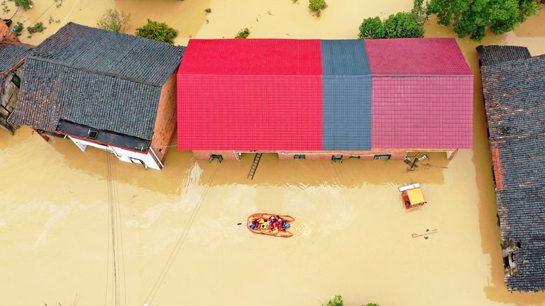 Rescuers cross floodwaters in Zixing, Hunan province, China. Pic: AP