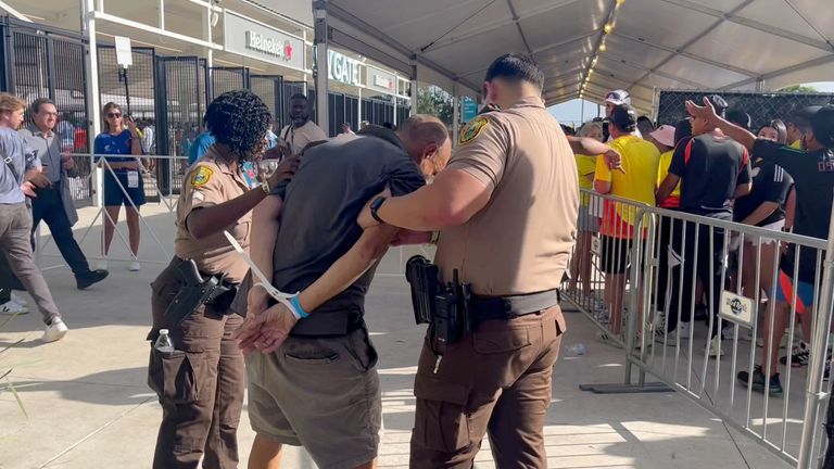 A man is detained by the police, amid reports of fans rushing the gates before the final match of Copa America between Argentina and Colombia at Hard Rock Stadium, in Miami, Florida, U.S., July 14, 2024, in this screengrab obtained from a social media video. sammbonu/via REUTERS THIS IMAGE HAS BEEN SUPPLIED BY A THIRD PARTY. MANDATORY CREDIT. NO RESALES. NO ARCHIVES.