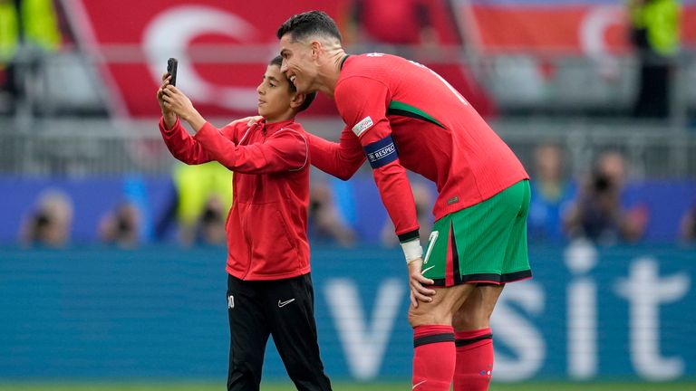 A young pitch invader takes a selfie with Cristiano Ronaldo during a game between Portugal and Turkey. Pic: AP