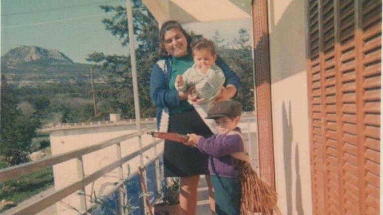 Mario with his mother and younger brother on the balcony of their former home in Komi Kebir