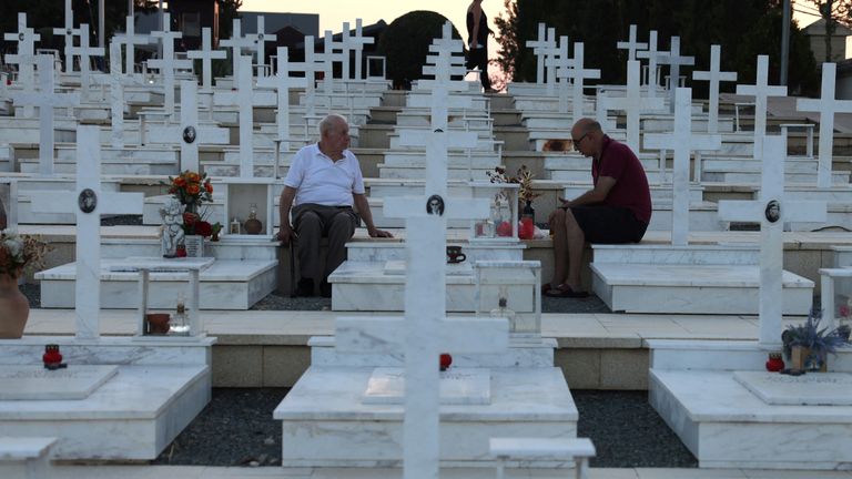 A man remembers his son with the dead man's brother at a military cemetery, in Nicosia, Cyprus, on the eve of the anniversary. Pic: Reuters