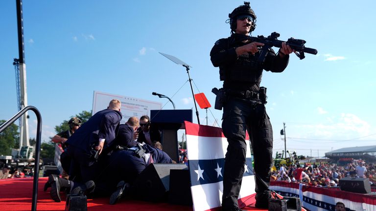 Donald Trump is covered by U.S. Secret Service agents at the campaign rally,
Pic: AP