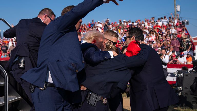 Donald Trump is helped off stage by U.S. Secret Service agents.
Pic: AP