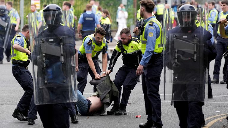 Officers detain a protester after violence at the former site of the Crown Paints factory in Coolock, north Dublin. Pic: PA