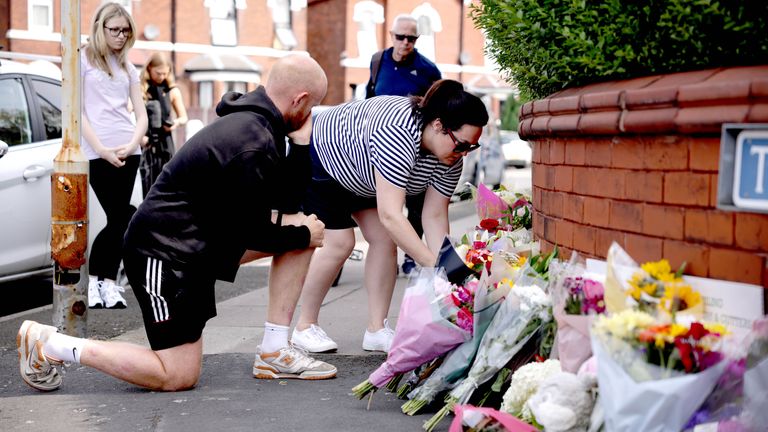 A person leaves flowers near the scene in Hart Street, Southport.
Pic: PA
