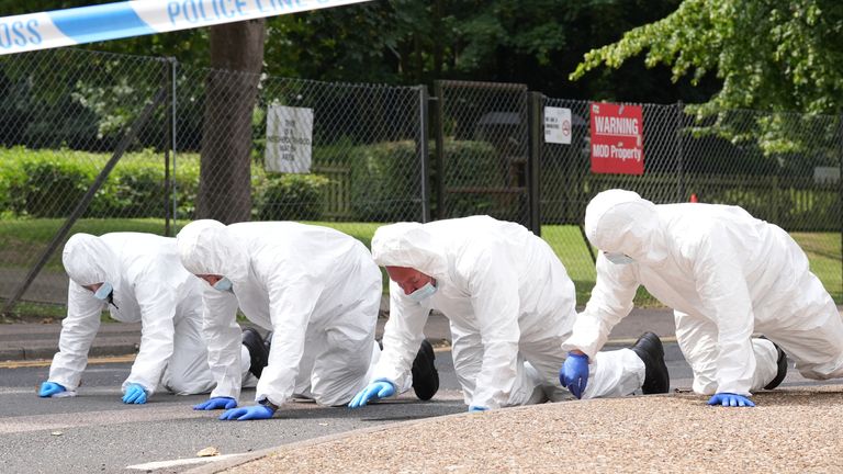 Forensic officers search near the scene of the stabbing