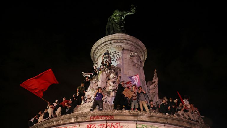 People climbed on the statue at Republique plaza during a protest against the far-right National Rally party which came out strongly ahead in first-round legislative elections, Sunday, June 30, 2024 in Paris. France's high-stakes legislative elections propelled the far-right National Rally to a strong but not decisive lead in the first-round vote Sunday, polling agencies projected, dealing another slap to centrist President Emmanuel Macron. (AP Photo/Thomas Padilla)