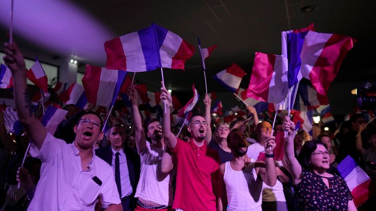 Supporters of French far right leader Marine Le Pen react after the release of projections based on the actual vote count in select constituencies , Sunday, June 30, 2024 in Henin-Beaumont, northern France. French voters propelled the far-right National Rally to a strong lead in first-round legislative elections Sunday and plunged the country into political uncertainty, according to polling projections. (AP Photo/Thibault Camus)