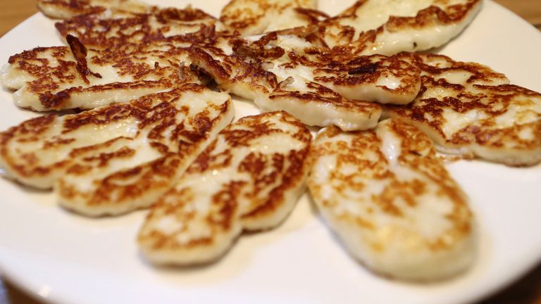 FILE - In this Wednesday Dec. 11, 2019 file photo, Cyprus' halloumi cheese is seen roasted on a plate at "Riverland" farm in Kampia village near Nicosia, Cyprus. Cyprus' agriculture minister on Tuesday, March 30, 2021 said the European Union's decision to recognize halloumi as a Cypriot traditional product will shield the country's top food export from an increasing number of foreign producers using the cheese's name to muscle into a 224 million euro ($267 million) market. (AP Photo/Petros Karad