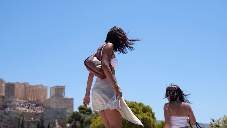 Dos mujeres ven la Acrópolis desde el monte Aerophagus en Atenas.  Imagen: AP