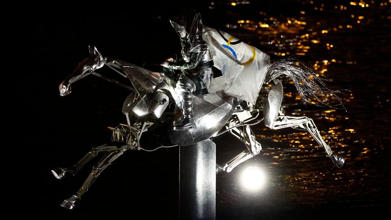 An animatronic metal horse took the Olympic flag up the Seine. Pic: Reuters