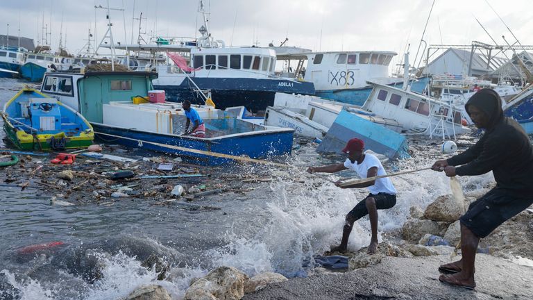Fishermen pull a boat damaged by Hurricane Beryl back to the dock at the Bridgetown Fisheries in Barbados, Monday, July 1, 2024. (AP Photo/Ricardo Mazalan)