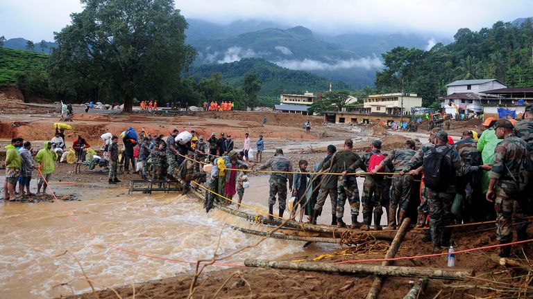 Army soldiers help trapped people to cross a temporary bridge at a landslide site after multiple landslides in the hills in Wayanad district, in the southern state of Kerala, India, July 31, 2024. REUTERS/CK Thanseer